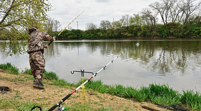 Nick Griffith fishes last April along the bank of the Great Miami River at Combs Park in Hamilton. STAFF FILE PHOTO/2016