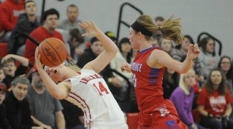 Cedarville’s Ise Bolender (left) is whacked by Allie Downing of Tri-Village in a girls high school basketball D-IV district final at Troy last March. MARC PENDLETON / STAFF