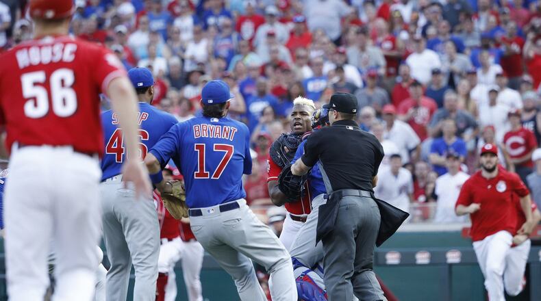 Yasiel Puig of the Cincinnati Reds is restrained after being hit by a pitch from Pedro Strop of the Chicago Cubs in the eighth inning at Great American Ball Park in Cincinnati on Saturday, June 29, 2019. The Cubs won, 6-0. (Joe Robbins/Getty Images)
