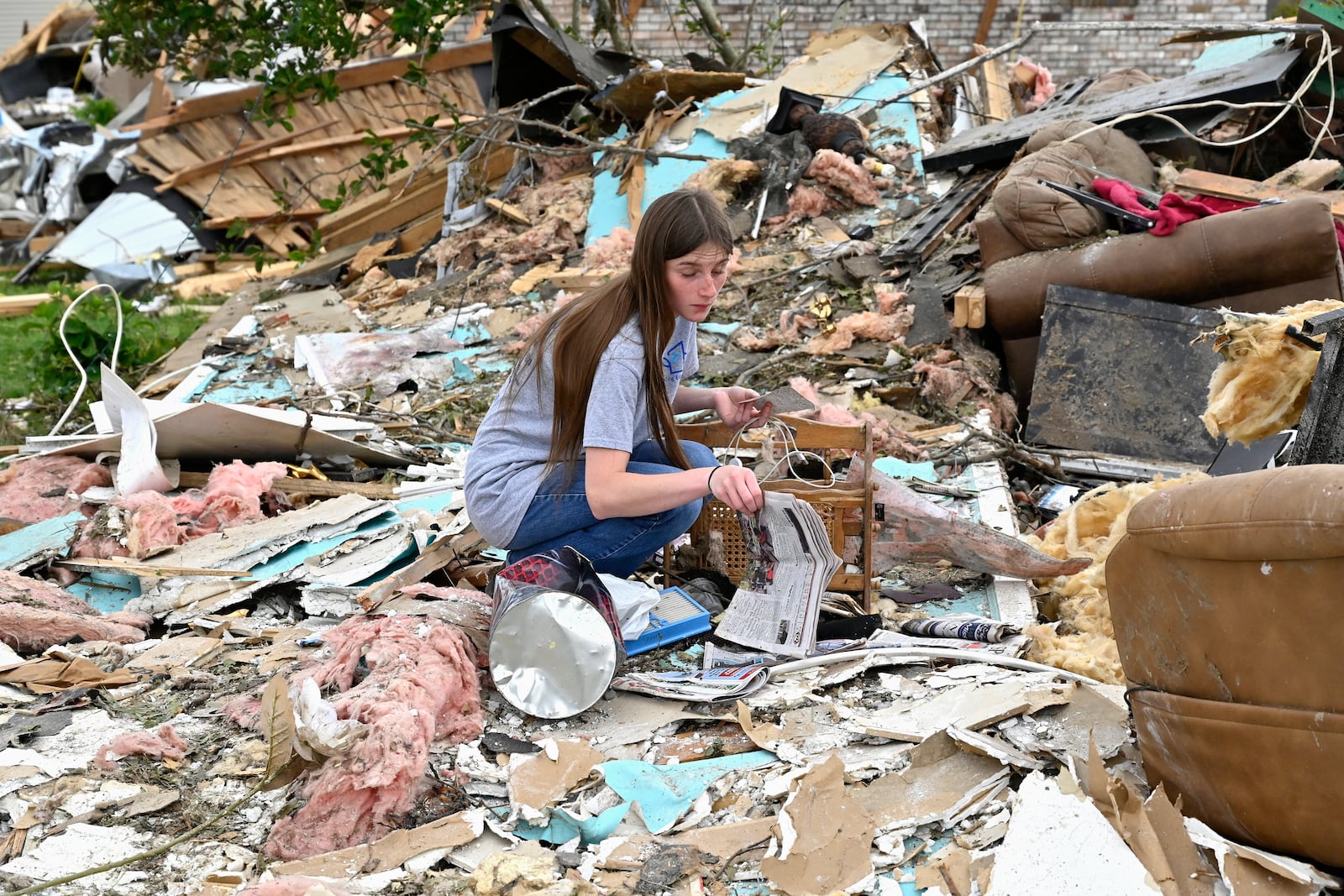 A volunteer goes through the remains of a home looking for what could be salvaged in the Sunshine Hills neighborhood in London, Ky., Monday, May 19, 2025. (AP Photo/Timothy D. Easley)