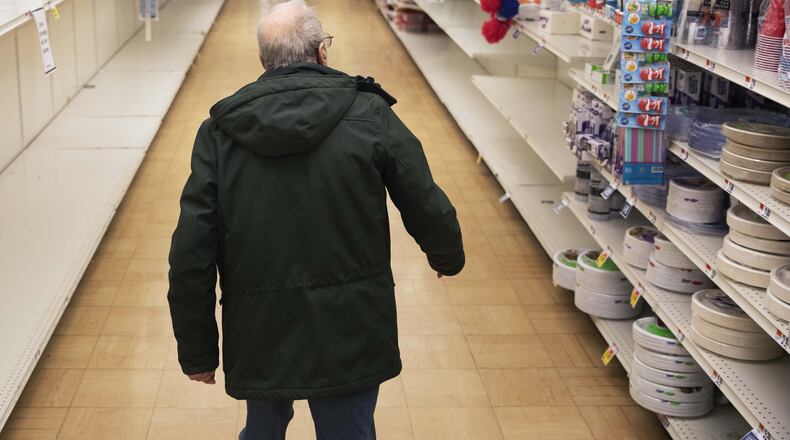 In this March 19, 2020 photo, a shopper looks for toilet paper at a Stop & Shop supermarket during hours open daily only for seniors in North Providence, R.I. Federal law enforcement is warning that scam artists are preying on older people’s fears by peddling fake tests for the coronavirus to Medicare recipients. (AP Photo/David Goldman)