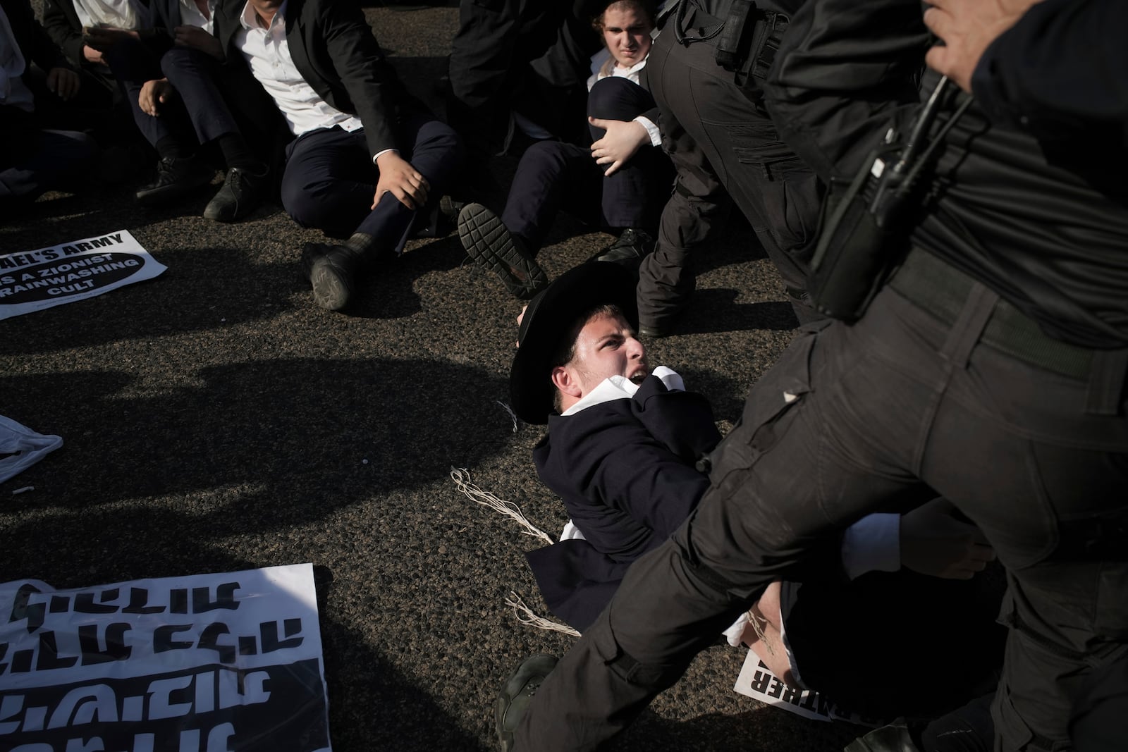 Israeli police officers disperse ultra-Orthodox Jewish men during a protest against army recruitment in Bnei Brak, Israel, Thursday, June 5, 2025. (AP Photo/Leo Correa)