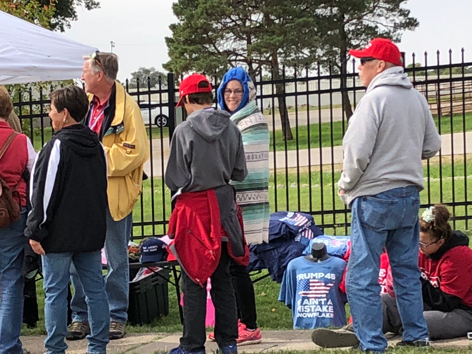 People wait in lines stretching outside the Warren County Fairgrounds for President Donald Trump’s appearance for a rally. 