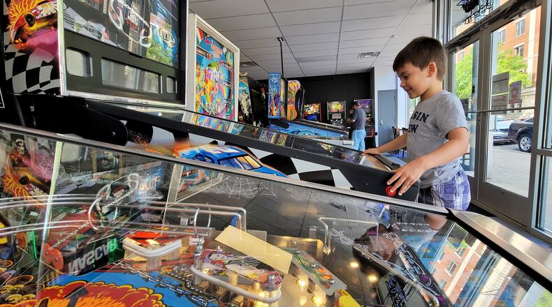 Judah Schram, 6, plays a game at Pinball Garage Thursday, May 20, 2021 in Hamilton. An expansion is planned for Pinball Garage that will add more pinball games and food options. NICK GRAHAM / STAFF