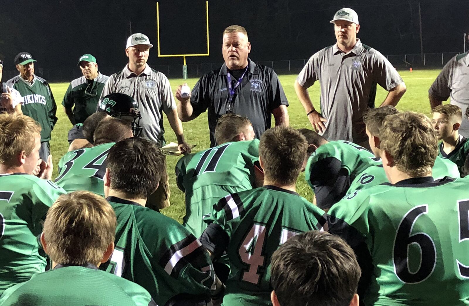 New Miami coach Jessie Hubbard talks to his team Saturday night after the Vikings opened the season with a 32-0 victory over visiting Gamble Montessori at Mara Field. RICK CASSANO/STAFF