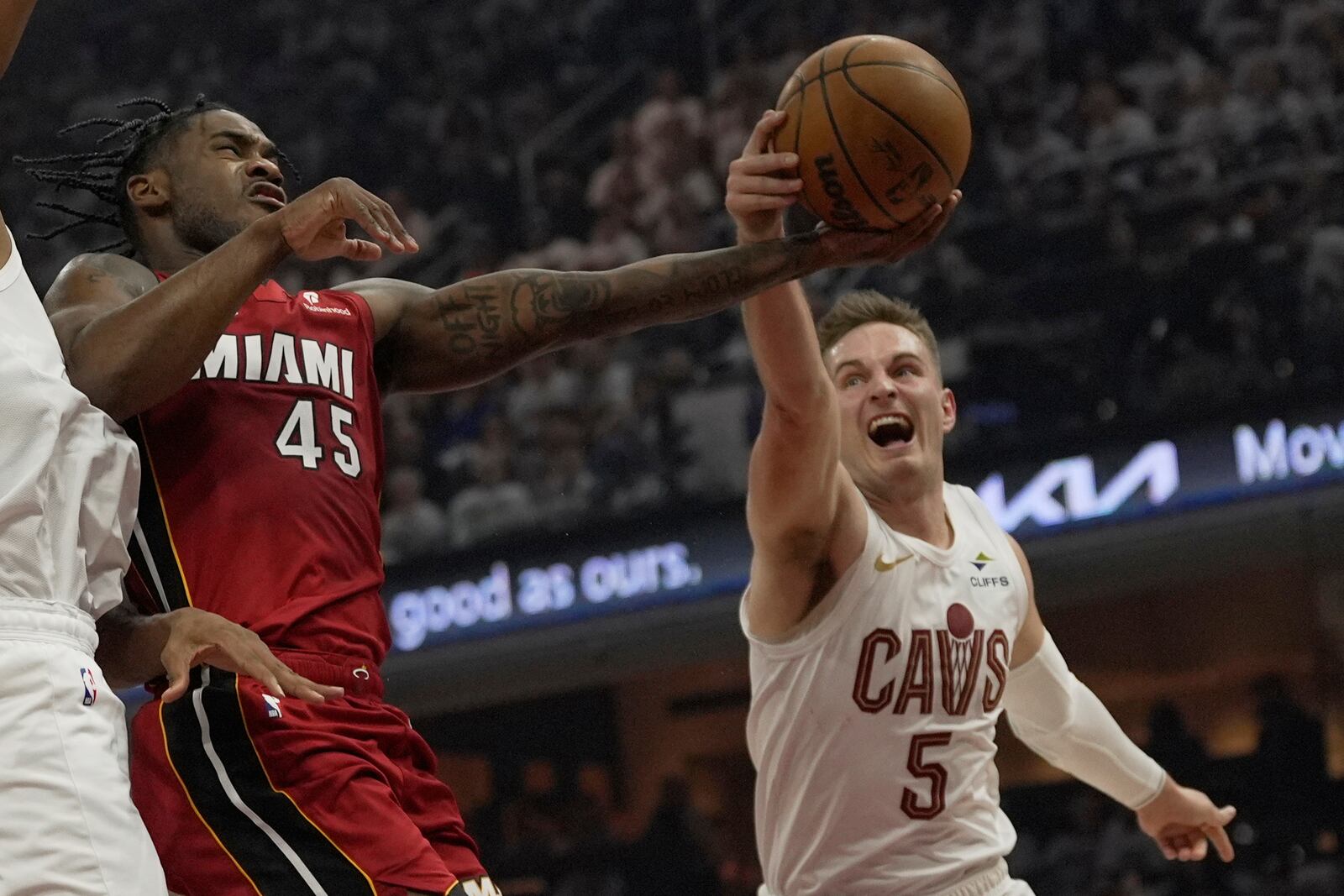 Cleveland Cavaliers guard Sam Merrill (5) knocks the ball away from Miami Heat guard Davion Mitchell (45) in the first half in Game 1 of an NBA first-round playoff series, Sunday, April 20, 2025, in Cleveland. (AP Photo/Sue Ogrocki)