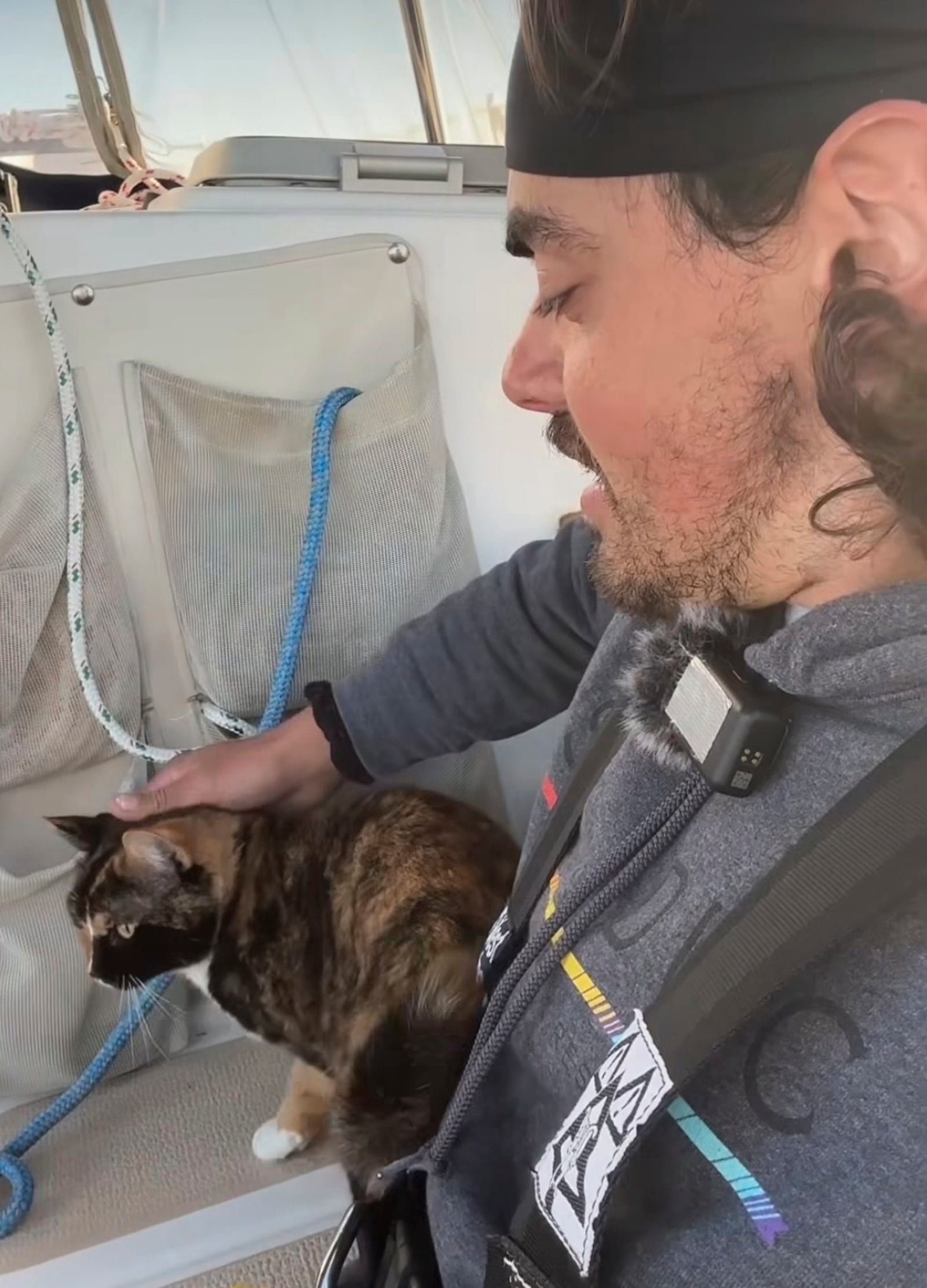 In this screengrab taken from a video posted on Oliver Widger's Instagram account on Friday, May 2, 2025, Widger pets his cat, Phoenix, on their sailboat somewhere in the Pacific Ocean as both make their way from Oregon to Hawaii. (Oliver Widger via AP)