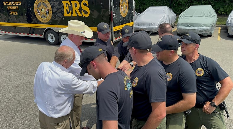 Butler County Sheriff Richard Jones, wearing a cowboy hat, participates in a huddle Wednesday, July 31, 2024, with the nine-member Emergency Response Services swiftwater/flood search and rescue team deploying to New Mexico. CONTRIBUTED