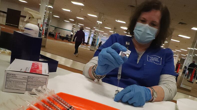 Jennie Router loads a syringe with the COVID vaccine Tuesday at the Clark County vaccine distribution center. BILL LACKEY/STAFF