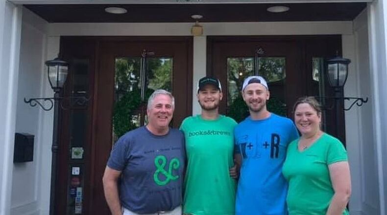 The Kamphaus family, from left, Neil, Connor, Logan and Ann Kamphaus are shown in front of Books & Brews on the day the sign was placed on the building at 107 E. Church St. CONTRIBUTED