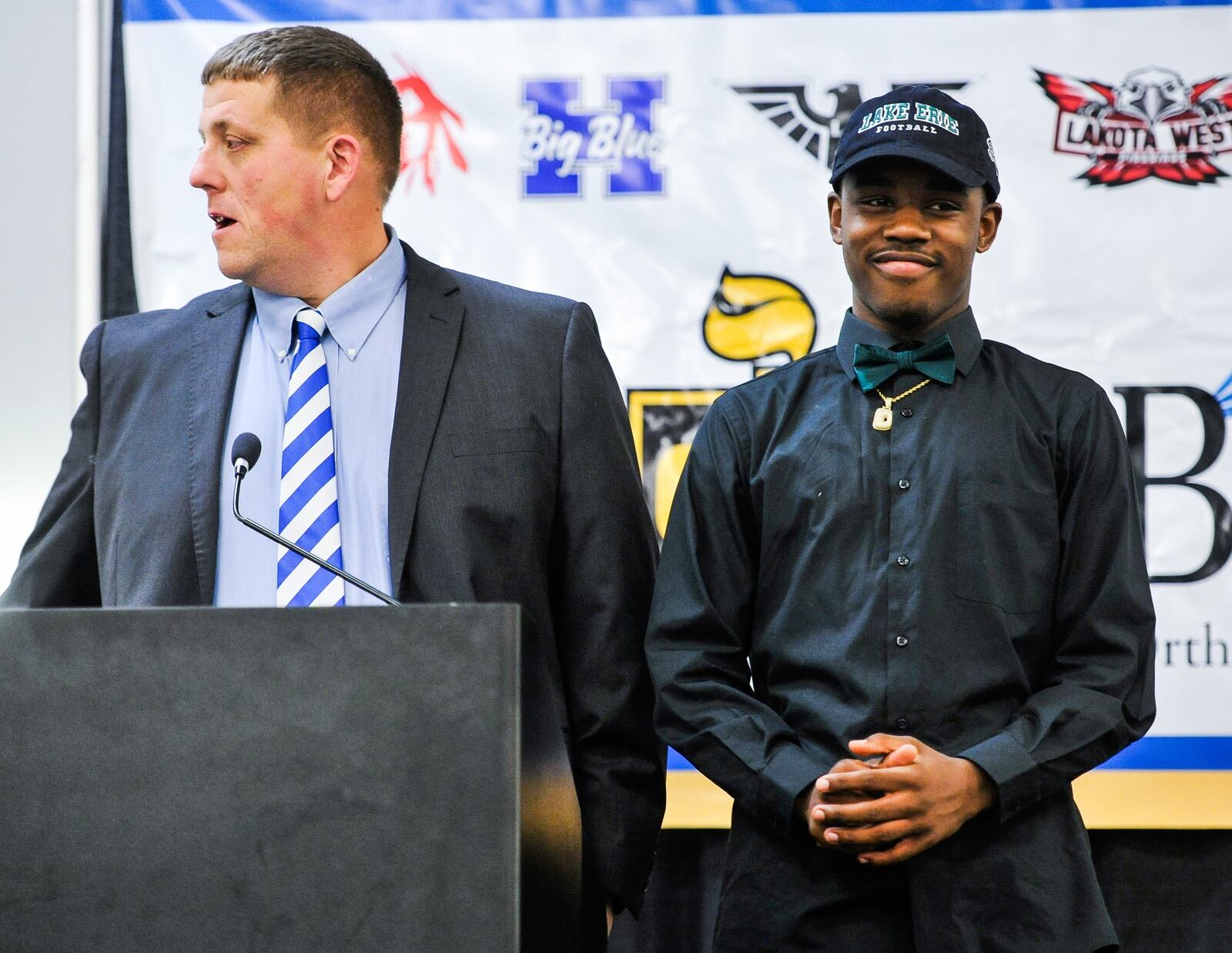 Hamilton assistant football coach Mike Dole stands with Leondre’ Pope during Wednesday’s Greater Miami Conference National Signing Day event at the Sharonville Convention Center. Pope has signed with Lake Erie College. NICK GRAHAM/STAFF