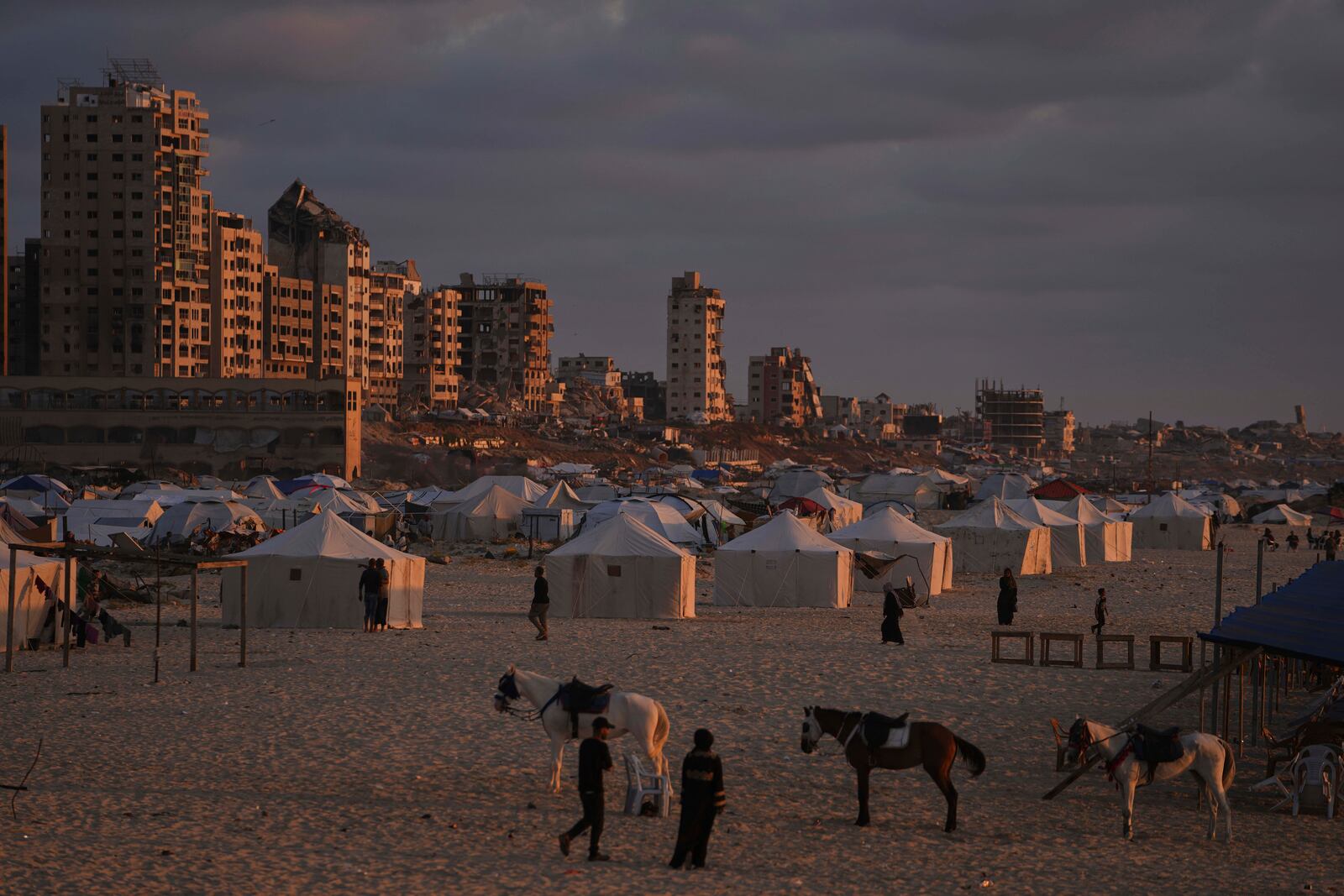 Displaced Palestinians walk along a makeshift tent camp at the shore of Gaza City on Thursday, May 22, 2025. (AP Photo/Jehad Alshrafi)