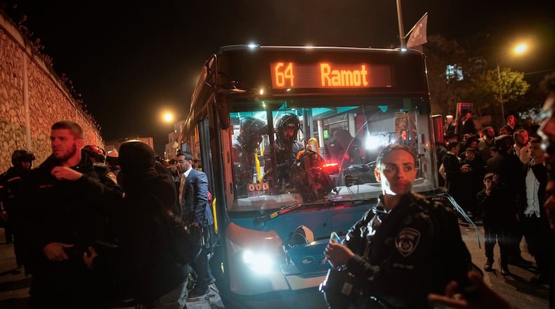 Israeli police inspect a bus following an incident in which it hit ultra-Orthodox Jewish demonstrators blocking a road during a protest against army recruitment in Jerusalem, Tuesday, Jan. 6, 2026. (AP Photo/Ohad Zwigenberg)