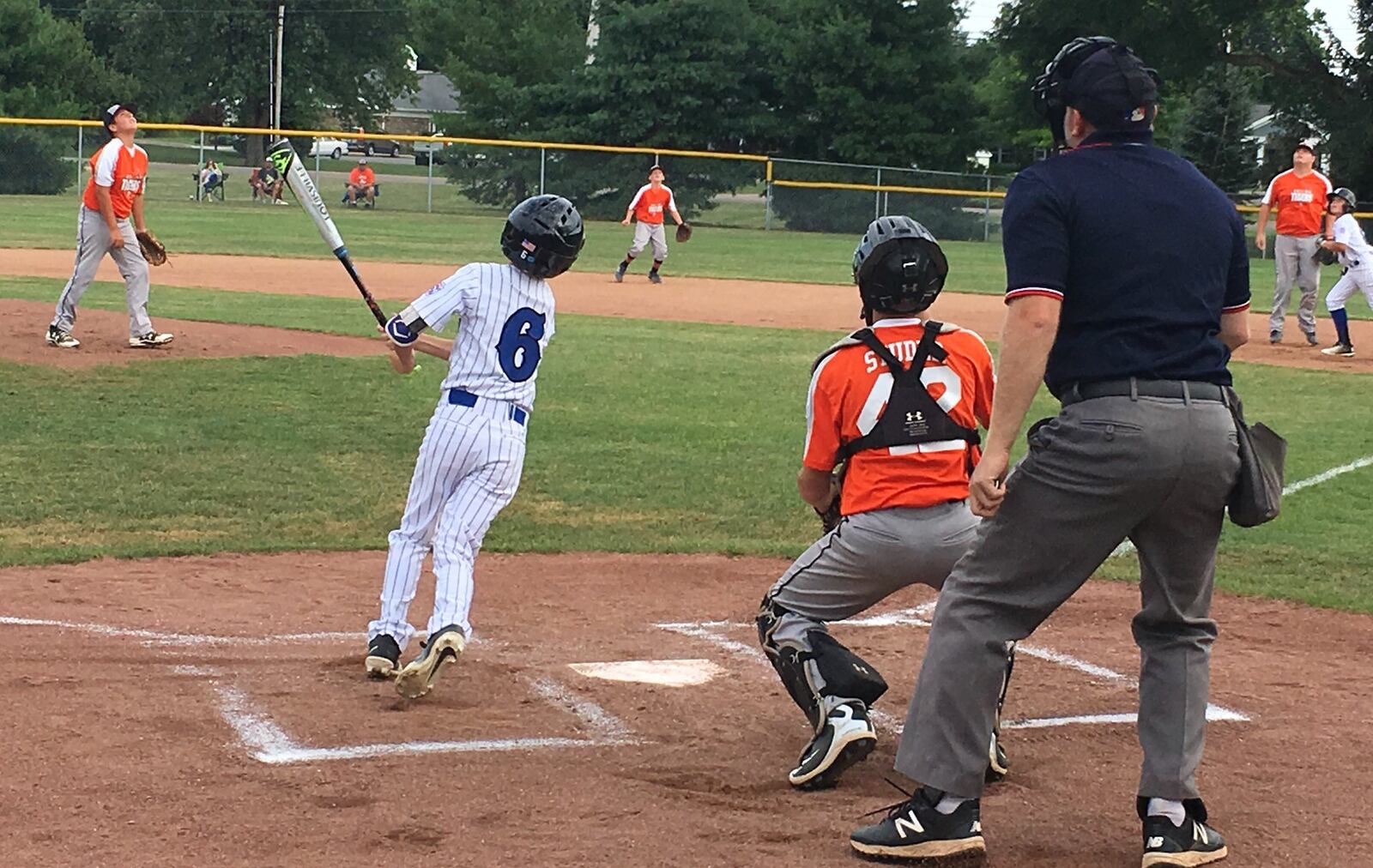 Everybody looks skyward as Hamilton West Side’s Sam Floyd sends the ball into the air Thursday night in the Ohio Little League Tournament at the Hoover Community Recreation Complex in North Canton. Galion’s players include pitcher Jayden Leach and catcher Chase Studer. West Side won 15-1. RICK CASSANO/STAFF
