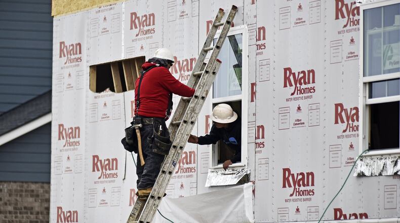 Construction crews work on the outside of a new home Monday, Jan. 28 in Monroe. Frigid temperatures are expected this week with temperatures dropping near zero. NICK GRAHAM/STAFF