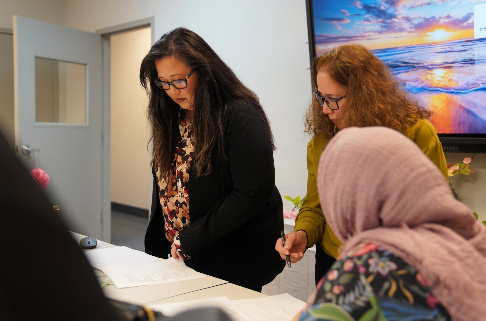 Kat Renfroe, a supervisor at Catholic Charities Migrant and Refugee Services, left, observes an Afghan refugee women's group at their offices in Fredericksburg, Va., on Tuesday, April 8, 2025. (AP Photo/Jessie Wardarski)