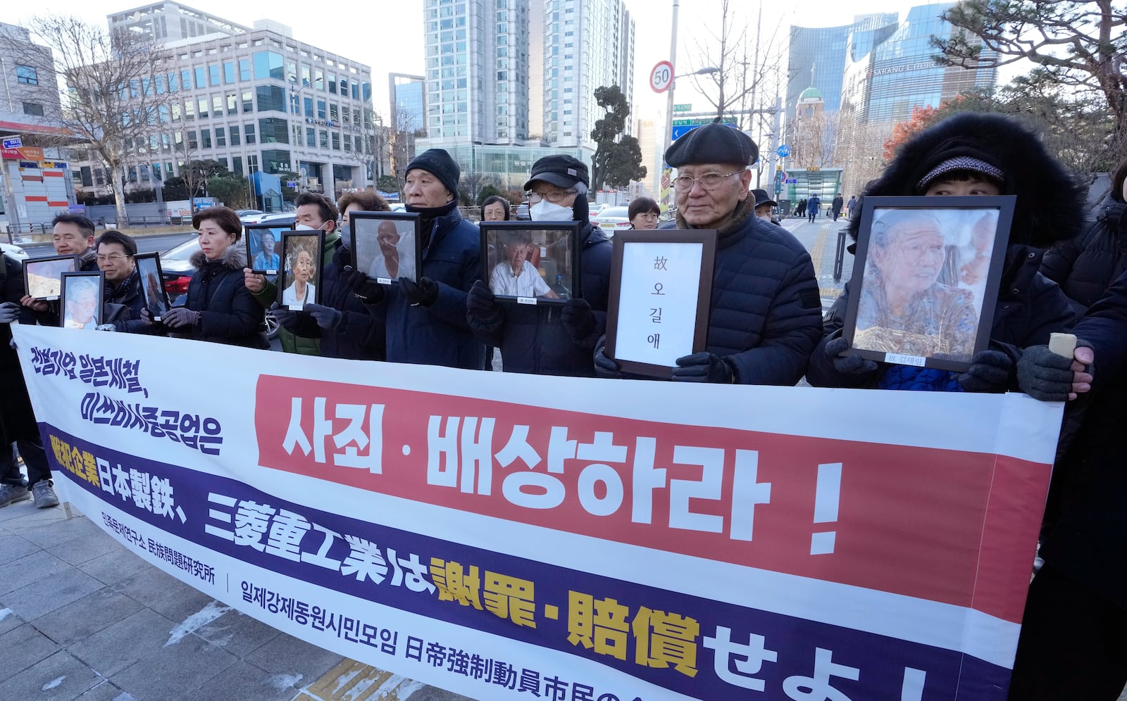 FILE - Family members of forced labor victims during the Japan's colonial period arrive at the Supreme Court in Seoul, South Korea, on Dec. 21, 2023. The sign reads "Mitsubishi Heavy Industries should compensate and apologize." (AP Photo/Ahn Young-joon, File)
