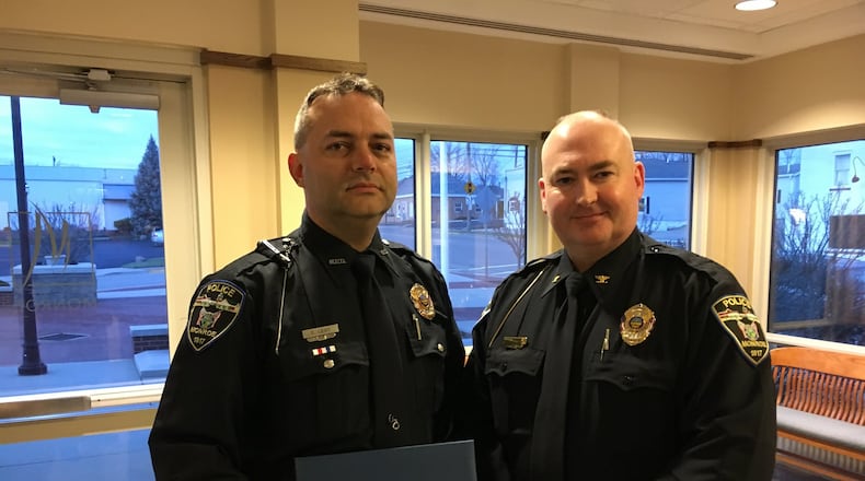 Monroe police Officer Doug Leist, left, received the Medal of Merit from police Chief Bob Buchanan during a Monroe City Council meeting. Leist was recognized for his actions following a fatal shooting at a Monroe residence last August. ED RICHTER/STAFF