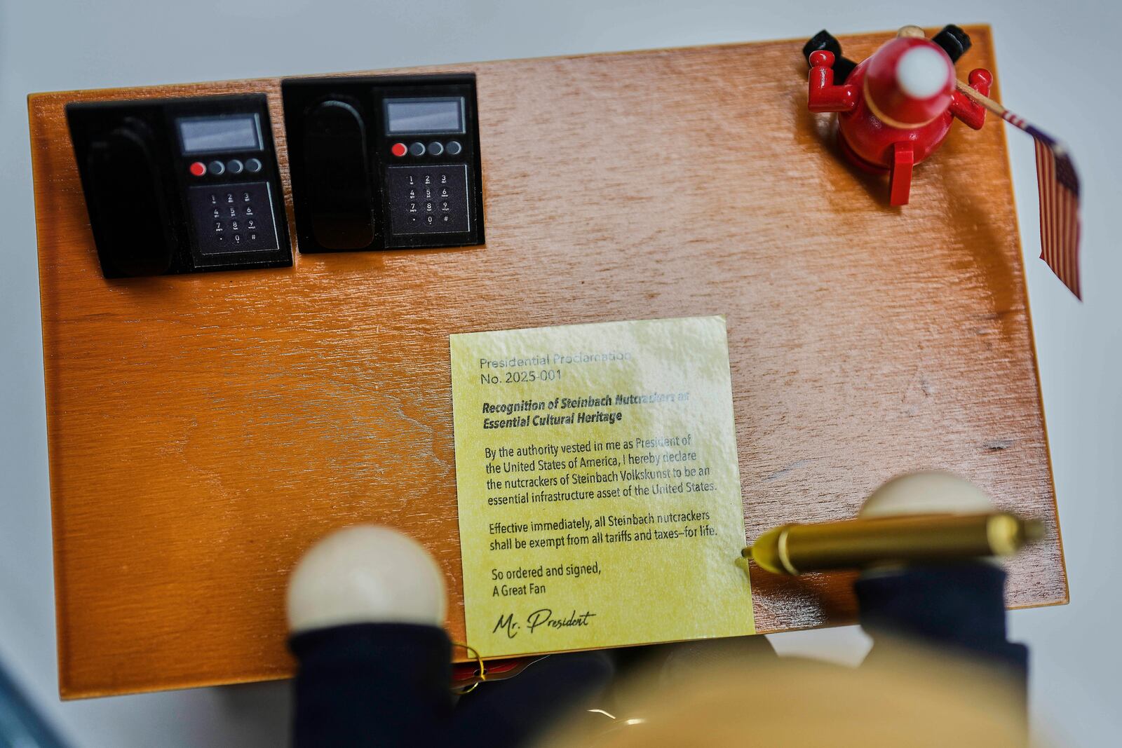The desk of the limited-edition nutcracker titled "Resolute Desk of the President," featuring a seated figure signing a "presidential proclamation," is seen at the Steinbach-Volkskunst nutcracker factory in Marienberg, Germany, Tuesday, April 15, 2025. (AP Photo/Markus Schreiber)