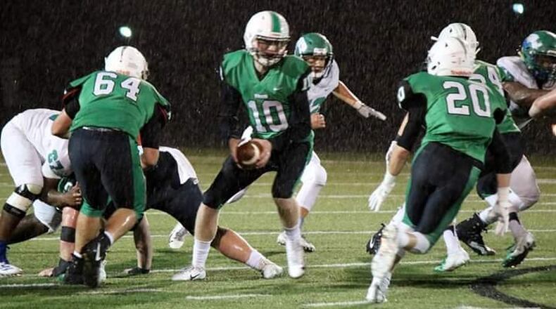 Badin’s Zach Switzer (10) is about to hand off to Alex DeLong (20) as Andrew Jones (64) provides some blocking in last Friday night’s 38-21 triumph over Chaminade Julienne at Fairfield Stadium in Fairfield. CONTRIBUTED PHOTO BY TERRI ADAMS