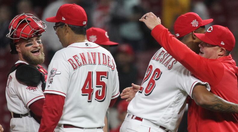 Reds reliever Raisel Iglesias hugs pitching coach Derek Johnson after a victory against the Braves on Tuesday, April 23, 2019, at Great American Ball Park in Cincinnati. David Jablonski/Staff