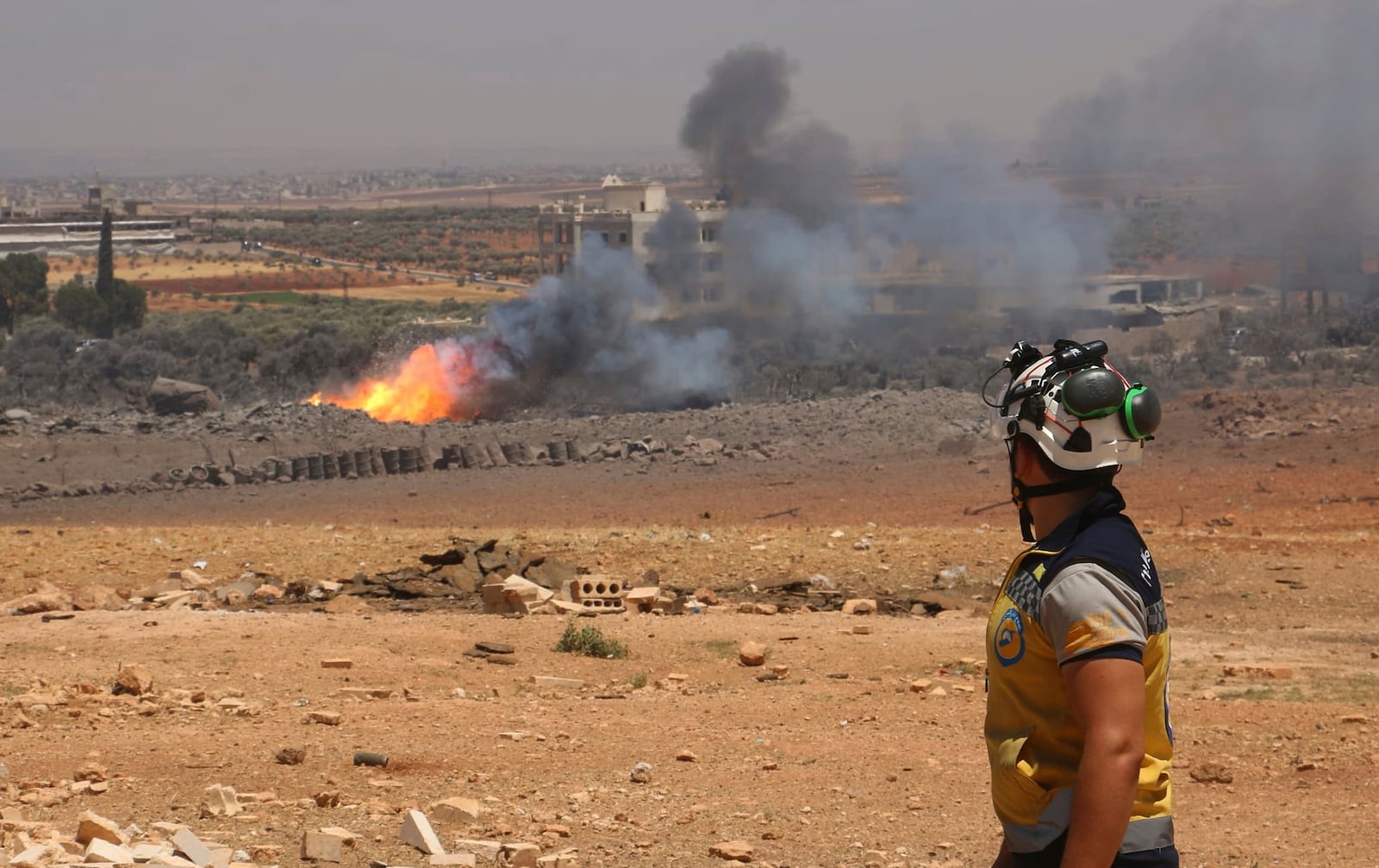 In this photo provided by the Syrian Civil Defense White Helmets, a Syrian Civil Defense worker checks the explosion scene in Maarat Misrin village, in Idlib province, north Syria, Thursday, July, 24, 2025. (Syrian Civil Defense White Helmets via AP)