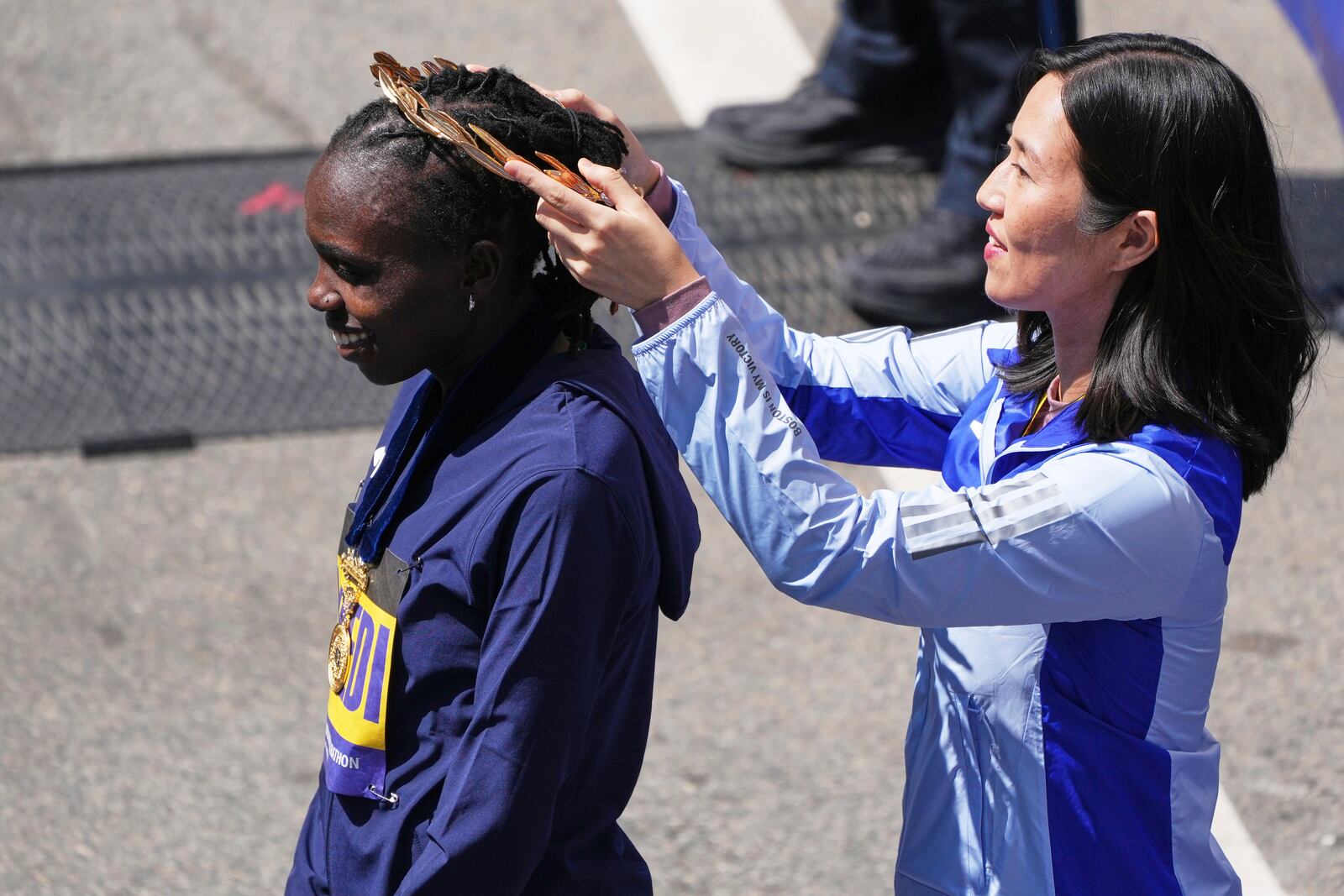 Sharon Lokedi, of Kenya, dons a wreath by Boston Mayor Michelle Wu after winning the women's division of the Boston Marathon, Monday, April 21, 2025, in Boston. (AP Photo/Charles Krupa)