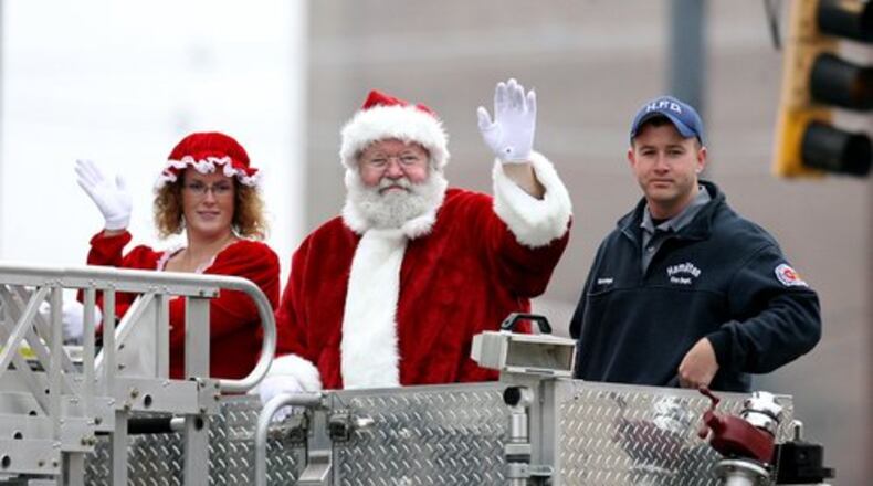 Mr. and Mrs. Claus wave atop a fire truck during the City of Hamilton's annual Santa Parade Saturday, Nov. 20, 2010, in downtown Hamilton.