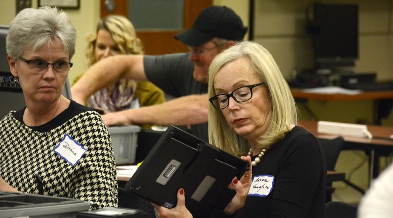 Poll worker Susan Vaughn, of Hamilton, receives training on the new electronic poll books election workers will use in this November’s general election on Nov. 7. MICHAEL D. PITMAN/STAFF