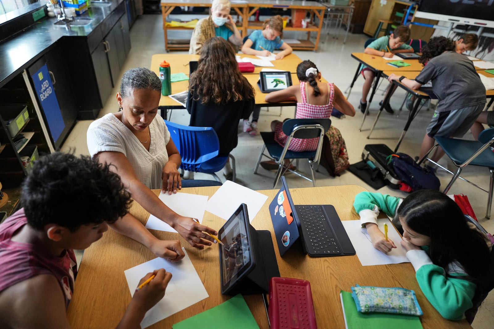 Art teacher Lindsay Johnson, second from left, teaches students how to ask ChatGPT for help during a summer class at Roosevelt Middle School, Wednesday, June 25, 2025, in River Forest, Ill. (AP Photo/Nam Y. Huh)