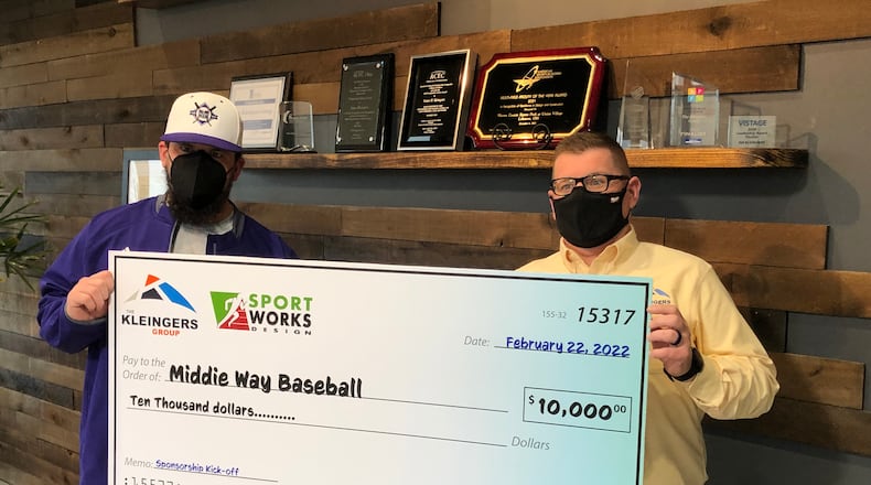 Tim Casto, right, president and CEO of The Kleingers Group, a civil engineering company based in West Chester, presents a $10,000 check to Kyle Schwarber, a Mddletown High School graduate and MLB player, Tuesday afternoon. The money will be used to purchase equipment for Middie Way Baseball. RICK McCRABB/STAFF