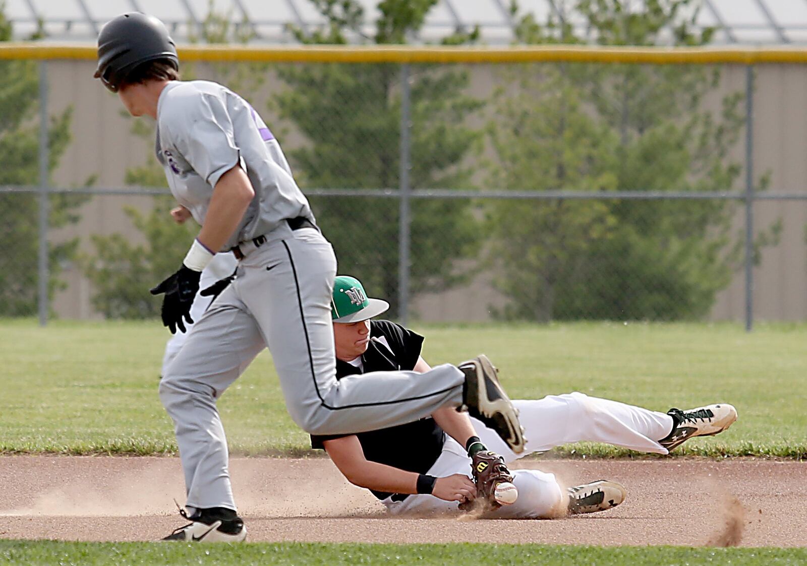 New Miami second baseman Jordan Phillips tries to field a Miami Valley Christian Academy ground ball as MVCA’s Nathaniel Scheffer runs to second during their Division IV sectional final Wednesday at Kings. CONTRIBUTED PHOTO BY E.L. HUBBARD