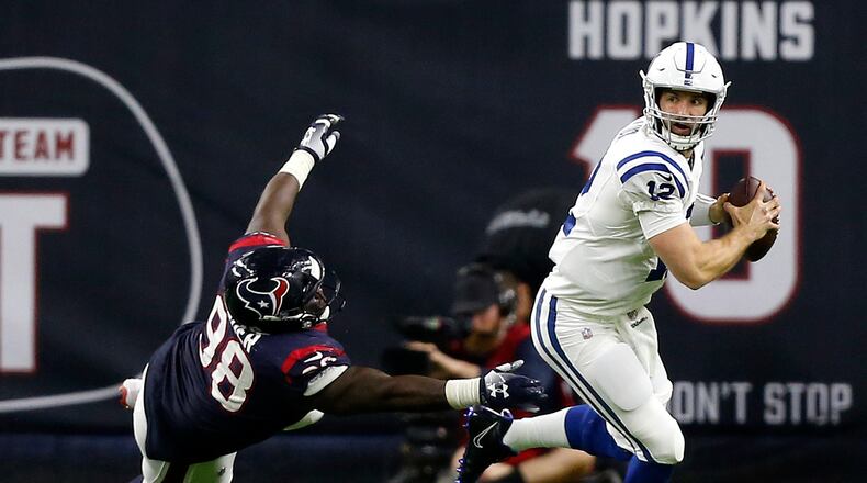 HOUSTON, TX - JANUARY 05: Andrew Luck #12 of the Indianapolis Colts avoids the tackle attempt by D.J. Reader #98 of the Houston Texans during the third quarter during the Wild Card Round at NRG Stadium on January 5, 2019 in Houston, Texas. (Photo by Bob Levey/Getty Images)