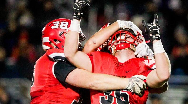 Madison’s Max Evans (38) and Cole Pelgen do some celebrating Saturday night during the Mohawks’ 50-6 victory over Cincinnati Hills Christian Academy in a Division V, Region 20 semifinal at Lakota East. NICK GRAHAM/STAFF