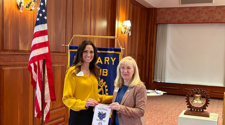 Kim Schmidt, left, president of the Hamilton Rotary Club, accepts a banner from the Ballymena, Northern Ireland Rotary Club from Karen Underwood Kramer, who visited there last month. RICK McCRABB/STAFF