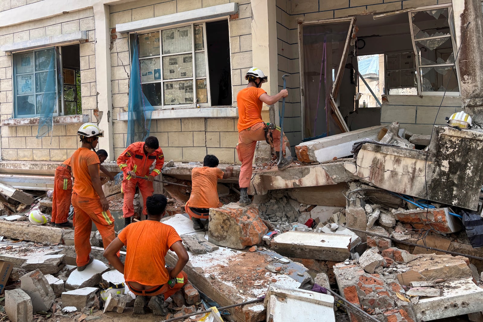 Firefighters recover the belongings of victims of the earthquake from damaged buildings that house Governments' servants in Naypyitaw, Myanmar, Monday, April 28, 2025. (AP Photo/Aung Shine Oo)