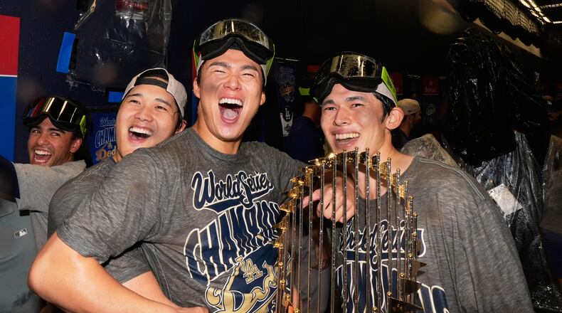 Los Angeles Dodgers pitcher Shohei Ohtani, pitcher Yoshinobu Yamamoto and pitcher Roki Sasaki celebrate after their win against the Toronto Blue Jays in Game 7 of baseball's World Series, Sunday, Nov. 2, 2025, in Toronto. (AP Photo/Brynn Anderson)