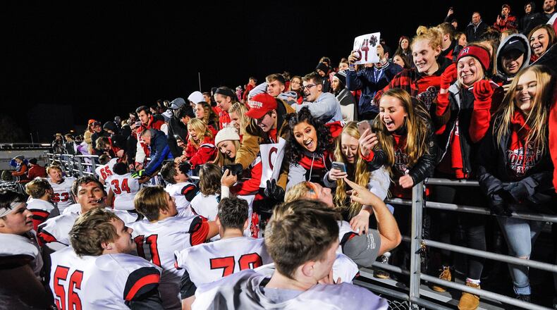 Madison’s players celebrate with their student section last Friday night after the Mohawks defeated West Jefferson 42-7 in the Division V, Region 20 championship game at Frank Zink Field in Beavercreek. NICK GRAHAM/STAFF