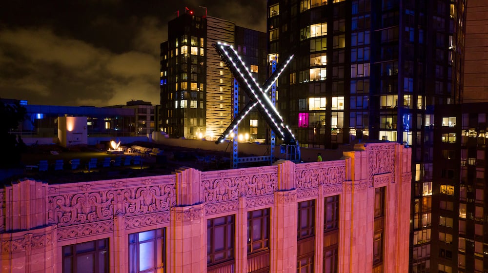 FILE - Workers install lighting on an "X" sign atop the company headquarters, formerly known as Twitter, in downtown San Francisco, July 28, 2023. (AP Photo/Noah Berger, File)
