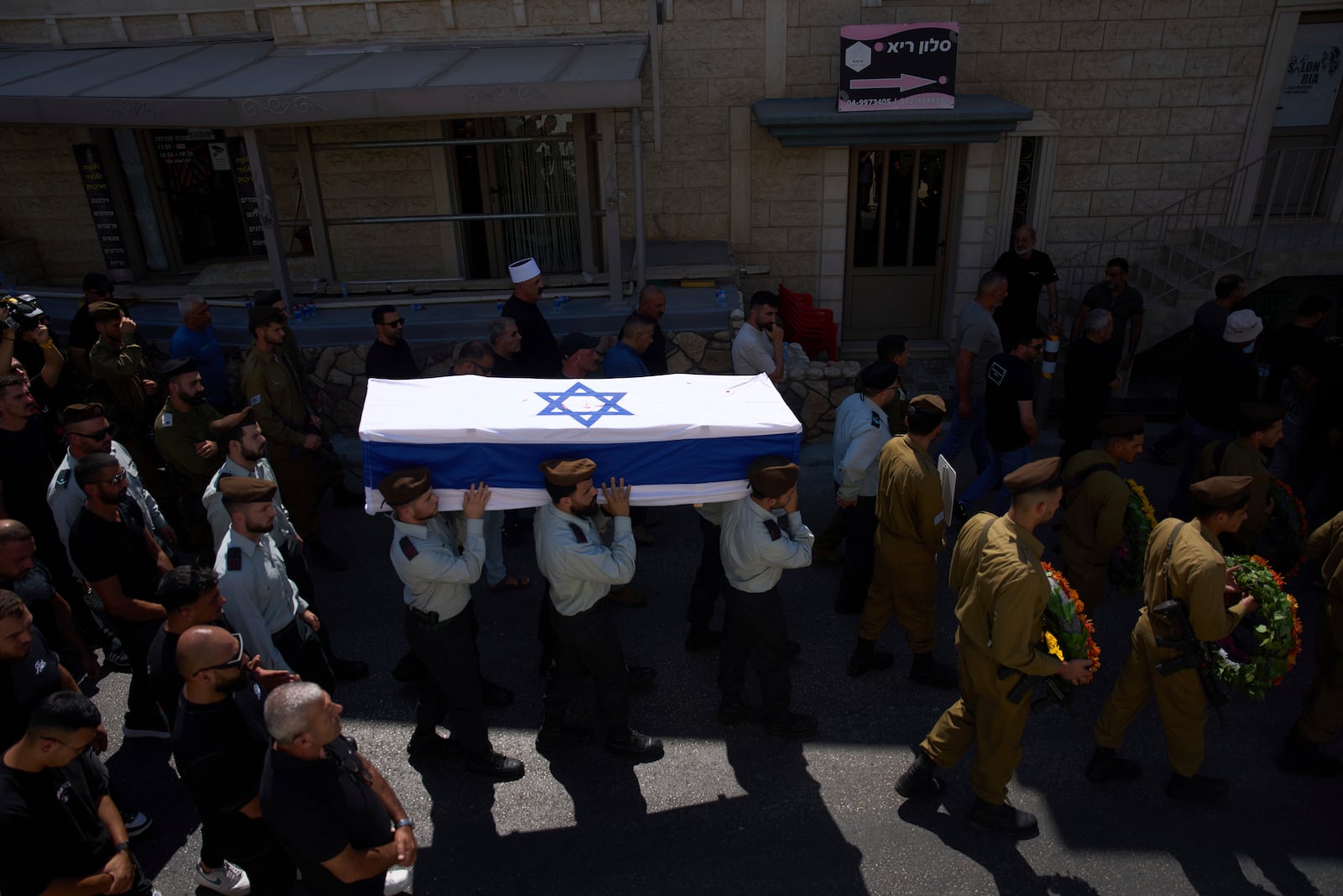 Israeli soldiers carry the coffin of Druze Israeli captain Amir Saad who was killed in a battle in the Gaza Strip, during his funeral in the village of Yanuh Jat, northern Israel, Sunday, July 27, 2025. (AP Photo/Ariel Schalit)