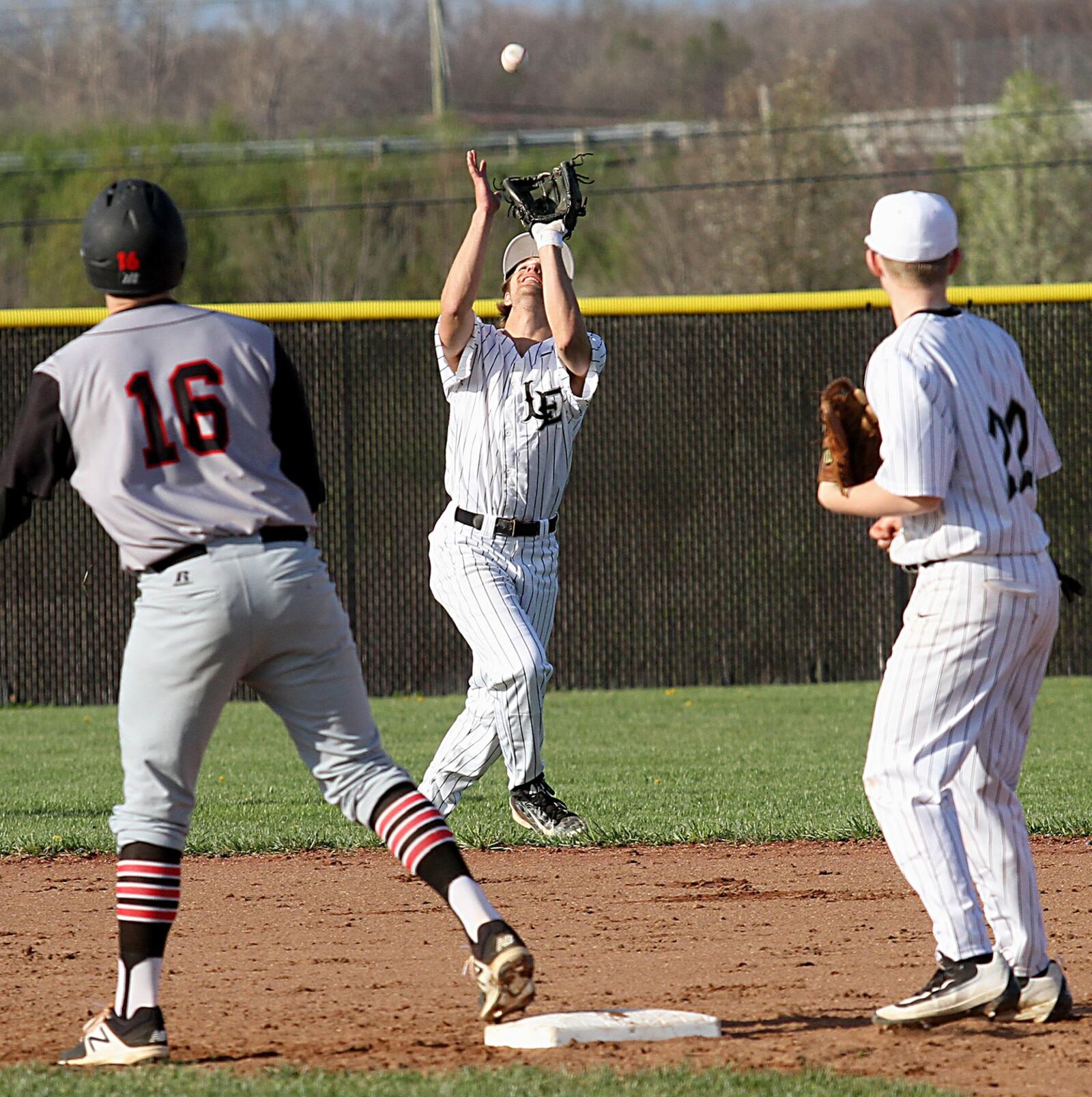 Lakota East’s Jefferson Szydlowski catches an Oak Hills popup as teammate Zach Holliday (22) and Brett Kron (16) of Oak Hills watch during Tuesday’s game in Liberty Township. CONTRIBUTED PHOTO BY E.L. HUBBARD