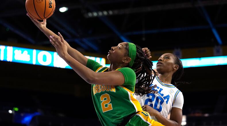 Oregon guard Chance Gray, left, shoots as UCLA guard Charisma Osborne defends during the first half of an NCAA college basketball game Sunday, Feb. 12, 2023, in Los Angeles. (AP Photo/Mark J. Terrill)