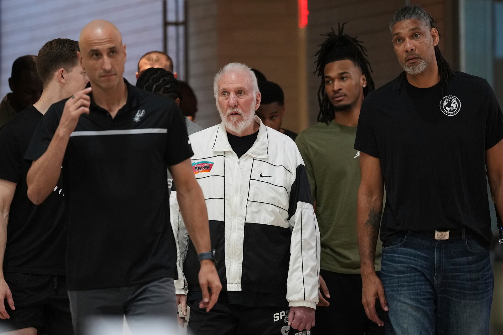 Former San Antonio Spurs head coach Gregg Popovich, center, arrives with current and former players where Mitch Johnson was introduced as the new head coach of the San Antonio Spurs NBA basketball team, in San Antonio, Monday, May 5, 2025. (AP Photo/Eric Gay)