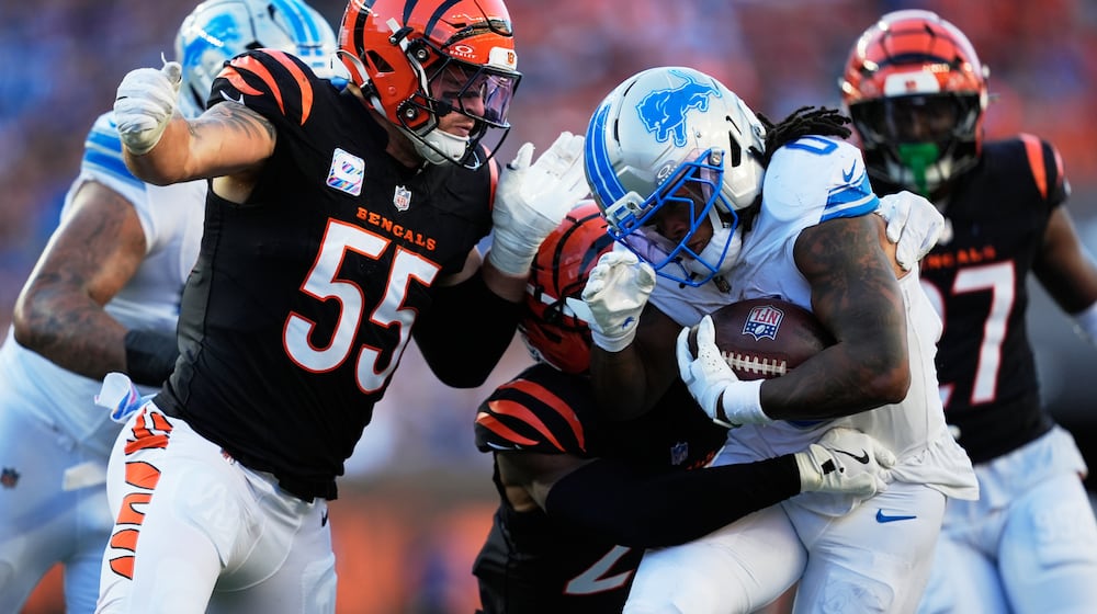 Detroit Lions running back Jahmyr Gibbs (0) runs through Cincinnati Bengals linebacker Logan Wilson (55) for a 20-yard touchdown reception during the second half of an NFL football game Sunday, Oct. 5, 2025, in Cincinnati. (AP Photo/Carolyn Kaster)