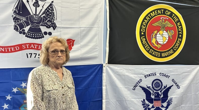 Shelia McClung is pictured in front of military flags at the Veterans Social Command in Trenton. CONTRIBUTED