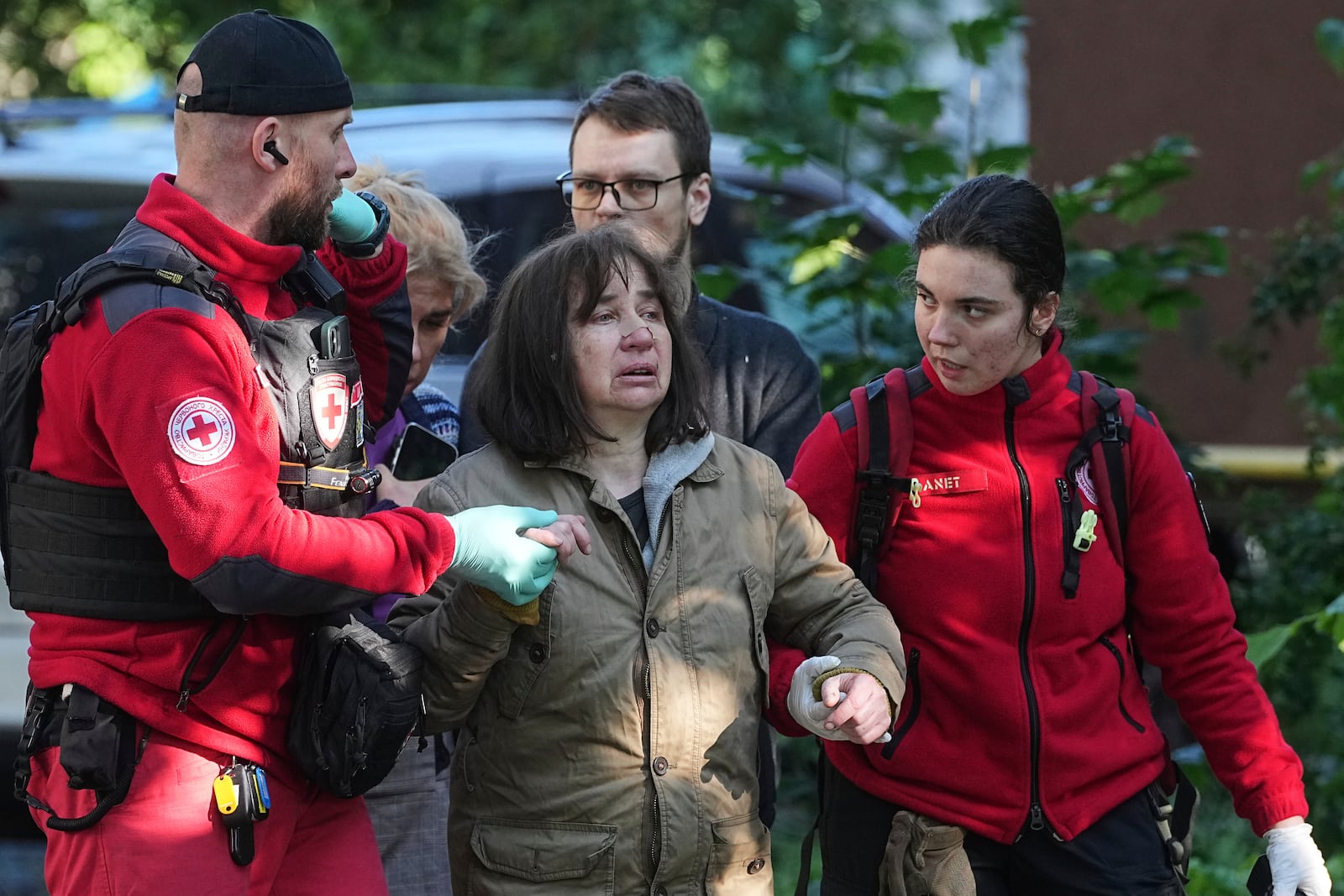 Medical workers help a woman in a yard of an apartment building destroyed after a Russian attack in Kyiv, Ukraine, early Monday, June 23, 2025. (AP Photo/Efrem Lukatsky)