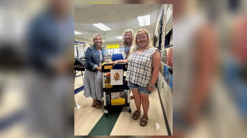 Samantha Melowic (right) is a recent special needs graduate from Monroe High School - and now a local college student - who has already left a lasting legacy gift for other students like herself.
Samantha Melowic, who earned her high school diploma in the spring and now is a freshman at Wright State University, created and donated a “sensory support cart” to her old school - to help students like herself. She is pictured with two of her former teachers who daily use her invention in their classrooms. (Contributed/ Journal-News)