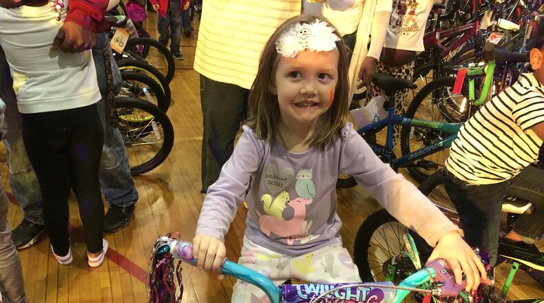 Tabitha Volle, 3, of Trenton, was all smiles after her raffle ticket was drawn Sunday during the 12th annual Louella Thompson Feed the Hungry Project Christmas Toy Giveaway at the Middletown Area YMCA. RICK McCRABB/STAFF