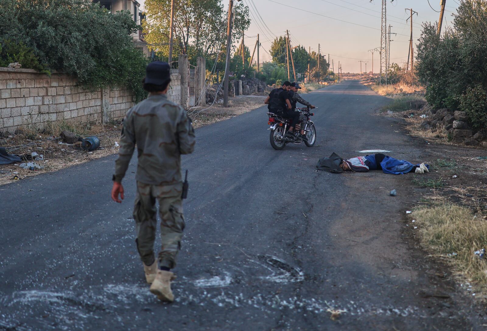 Syrian government forces pass next of a dead fighter from Druze militias, at Mazraa village on the outskirts of the city of Sweida, where clashes erupted between Sunni Bedouin clans and Druze militias, southern Syria, Monday, July 14, 2025. (AP Photo/Ghaith Alsayed)