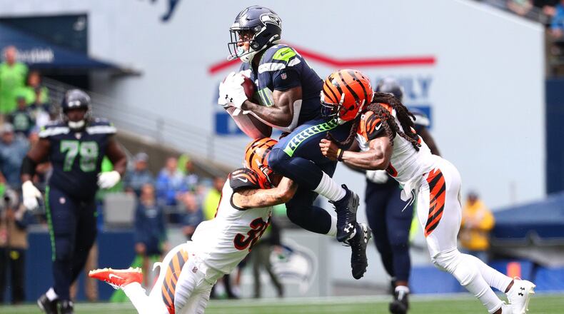 SEATTLE, WASHINGTON - SEPTEMBER 08: D.K. Metcalf #14 of the Seattle Seahawks completes a pass against Jessie Bates #30 (L) and B.W. Webb #23 of the Cincinnati Bengals in the third quarter during their game at CenturyLink Field on September 08, 2019 in Seattle, Washington. (Photo by Abbie Parr/Getty Images)